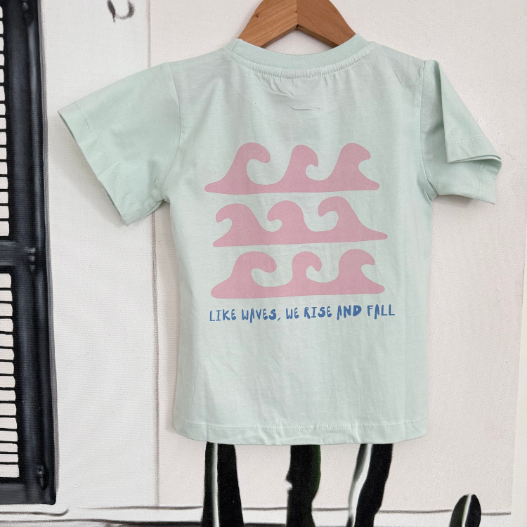 flatlay Boy blue mist Like Waves tee near the ocean. Handmade kids surf shirt for boys and girls.
