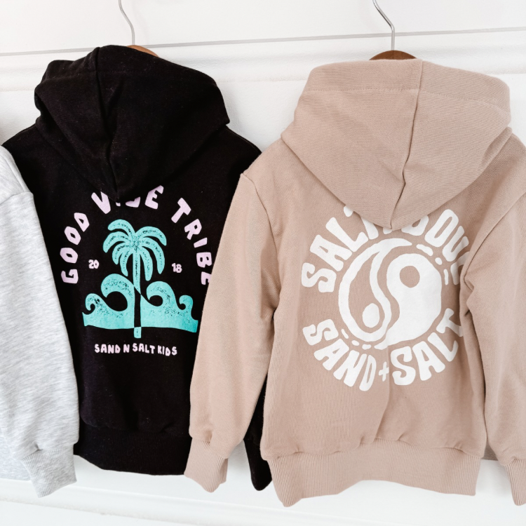 Sand beige kids hoodie with white “Salty Soul” logo. Coastal-inspired toddler sweatshirt for layering. Ethically crafted and made to last.
