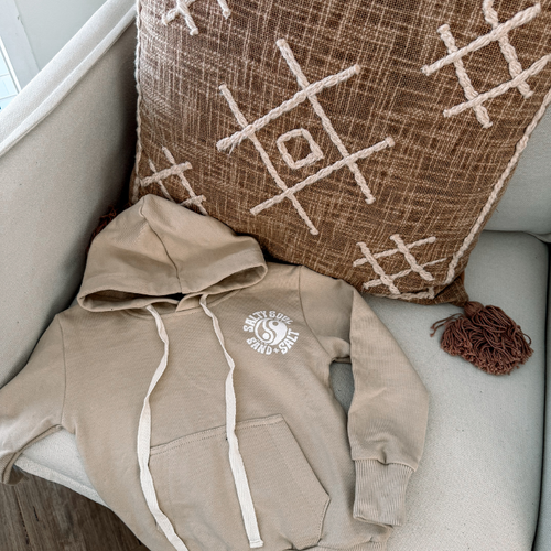 Sand beige kids hoodie with white “Salty Soul” logo. Coastal-inspired toddler sweatshirt for layering. Ethically crafted and made to last.