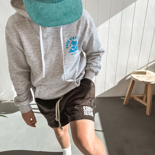 boys hooded jumper paired with cord shorts and cap on skateboard