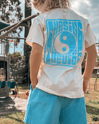 Child wearing aqua blue Chasing the Vibe t-shirt, skate park style