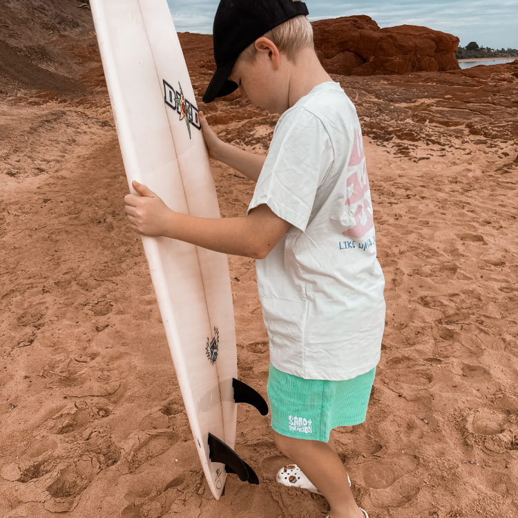 kids surf tshirt and cord shorts on the beach with cord cap